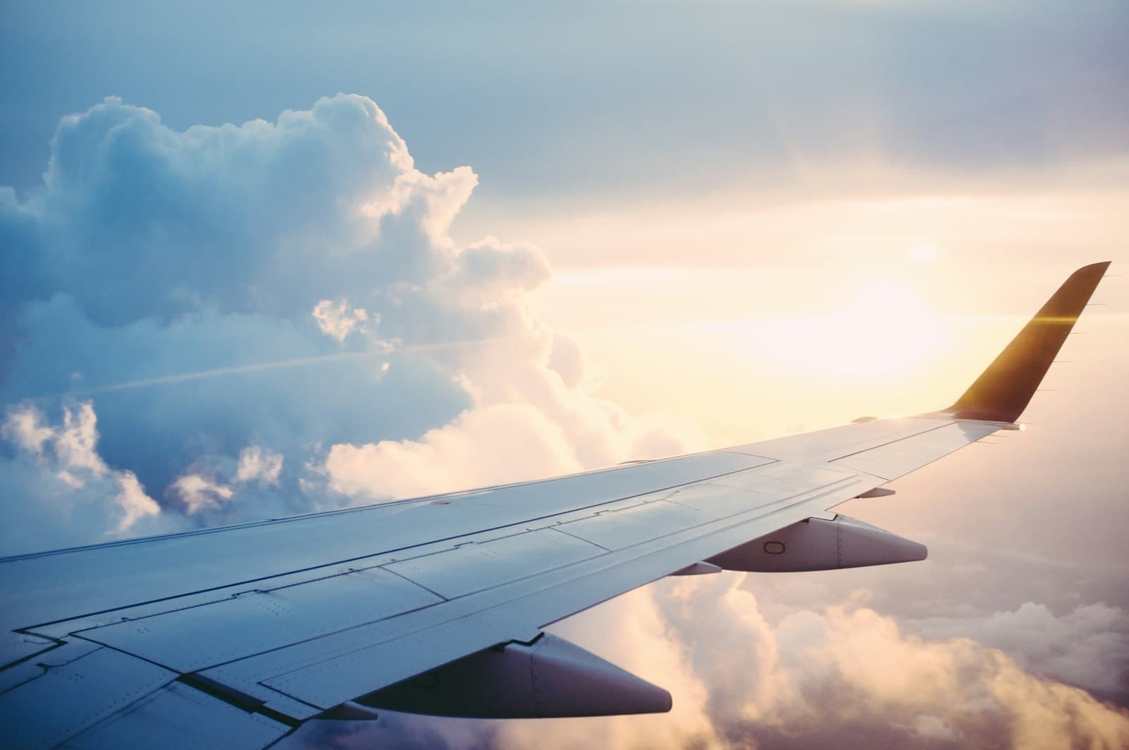 View of an aircraft wing above the clouds at sunset