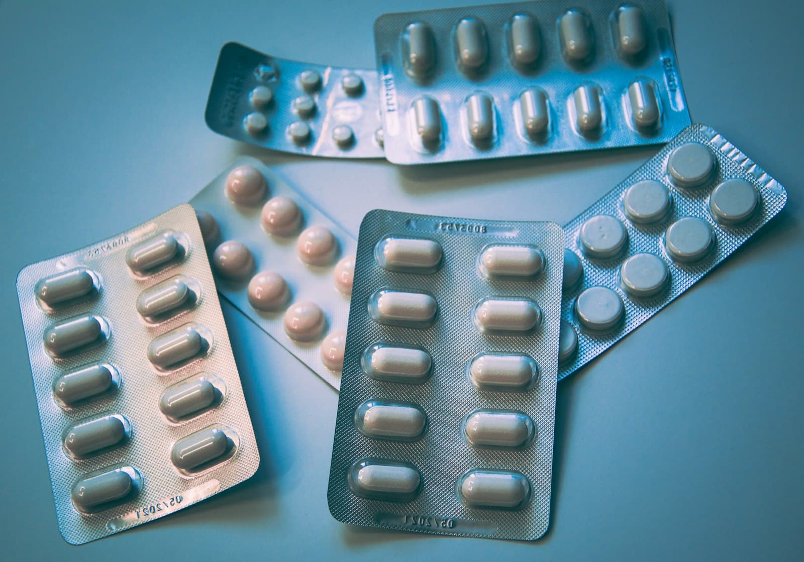Blister packs of medication on a soft blue background